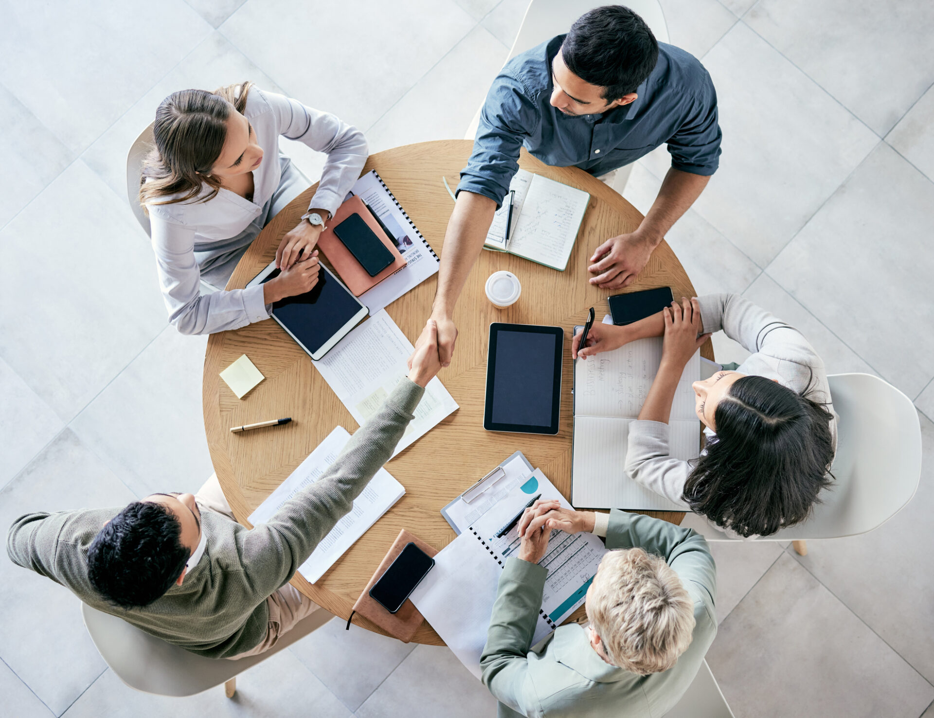 shot-of-businessmen-shaking-hands-during-a-team-meeting-in-a-modern-office
